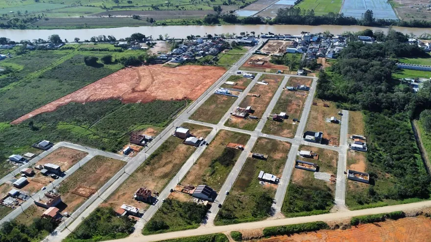 Vista aérea do Loteamento Cidade Jardim I, com as ruas, os lotes e a cidade ao fundo.